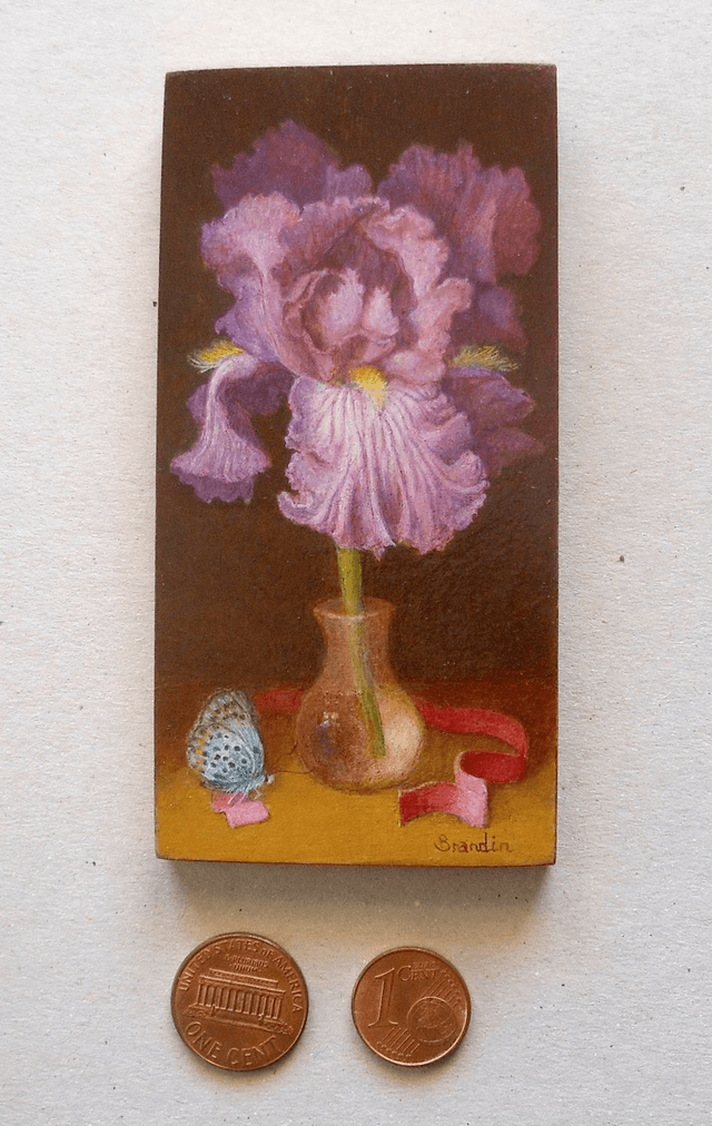 Small format oil painting of a still life with an iris in a translucent glass vial
