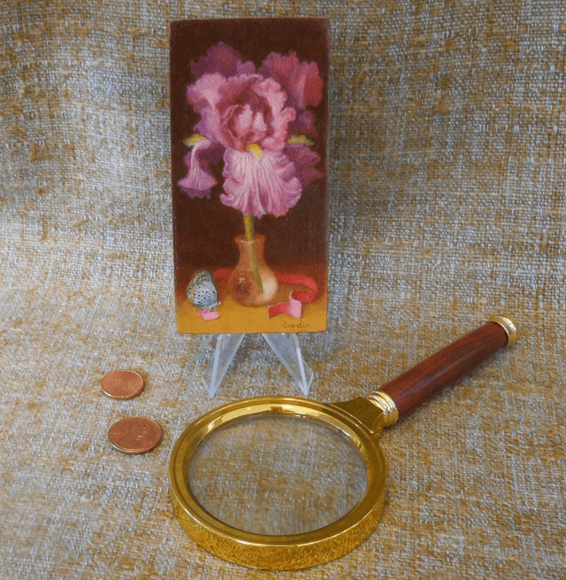 Small format oil painting of a still life with an iris in a translucent glass vial