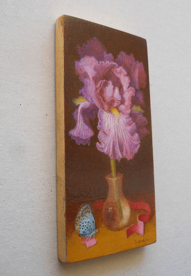 Small format oil painting of a still life with an iris in a translucent glass vial