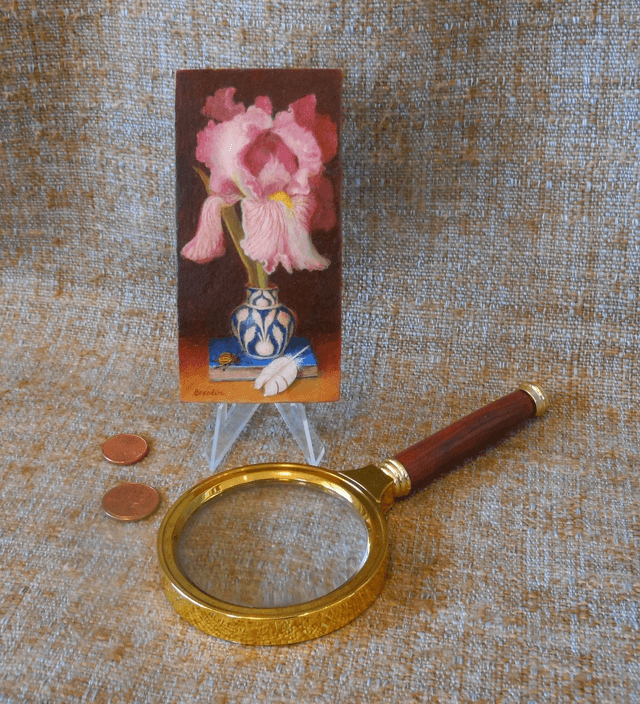 Still life with pink iris, blue book and white feather