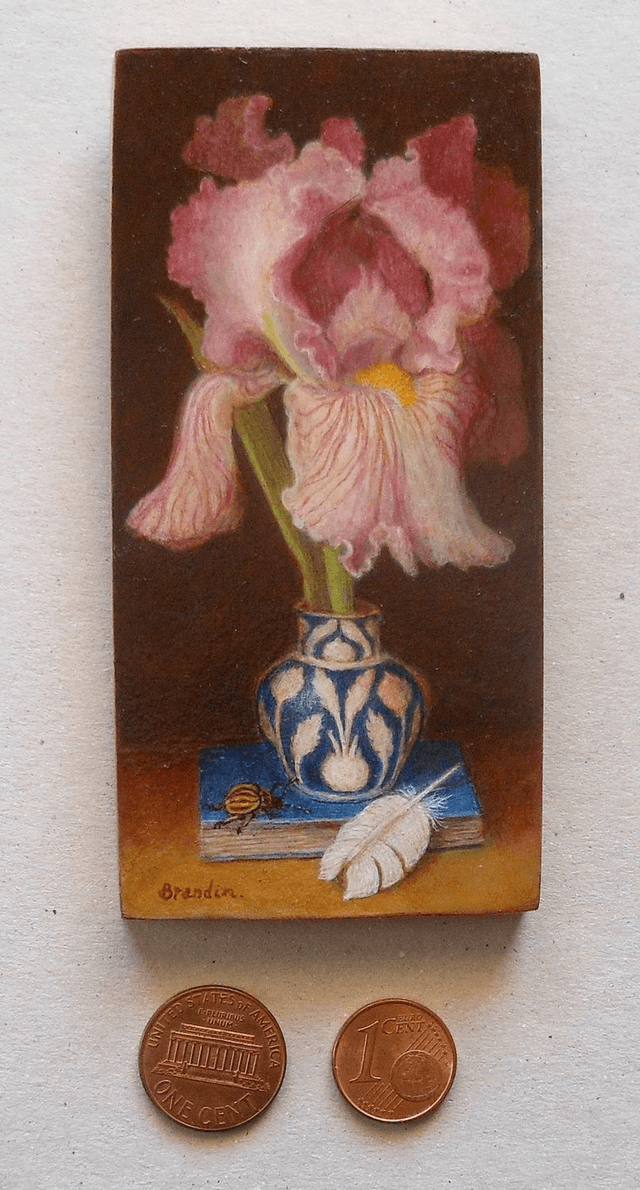 Still life with pink iris, blue book and white feather