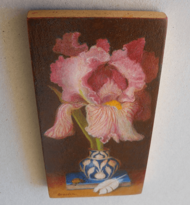 Still life with pink iris, blue book and white feather